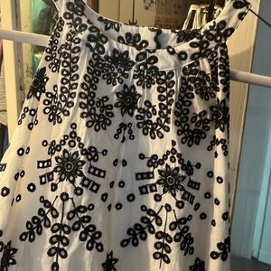 White with black embroidery, hits around the knee